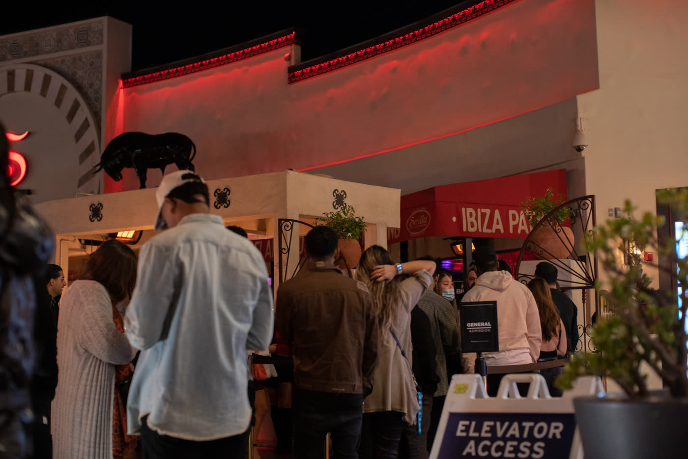 Guests lining up under the red-lit Ibiza Patio entrance, Costa Mesa.