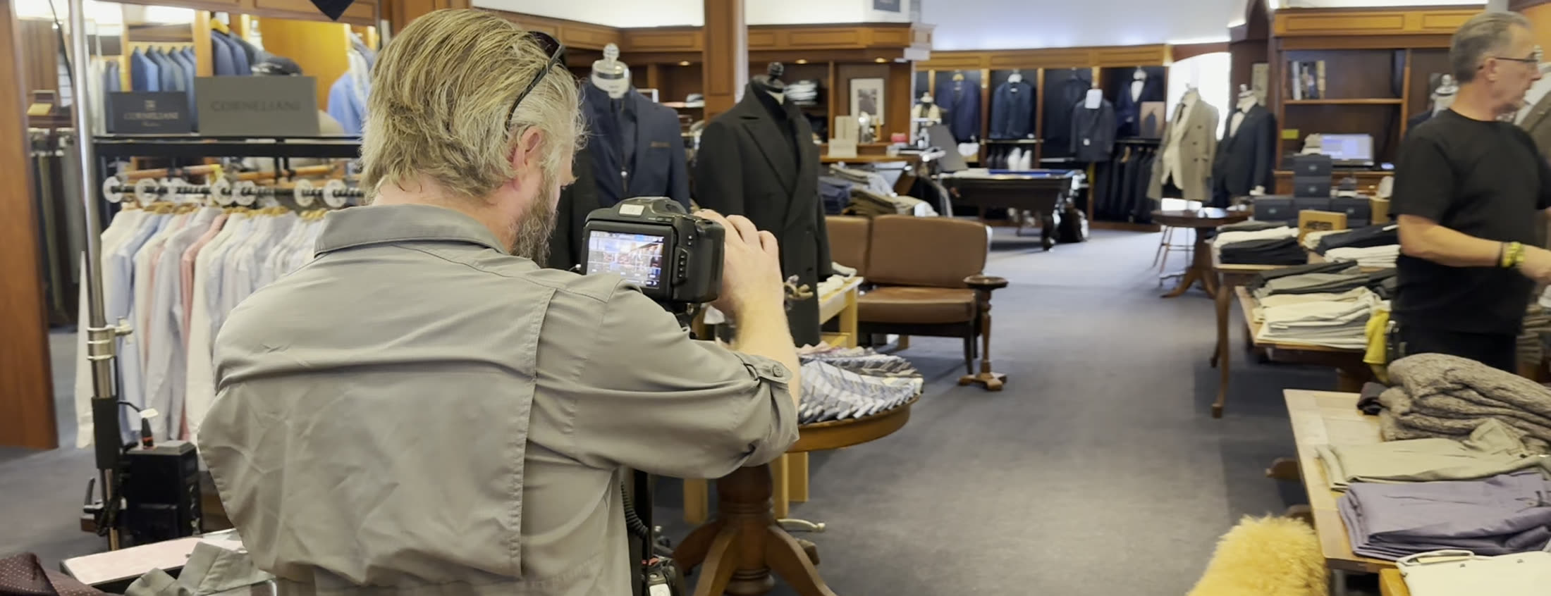 Camera operator filming on the Ascot Shop menswear floor in La Jolla